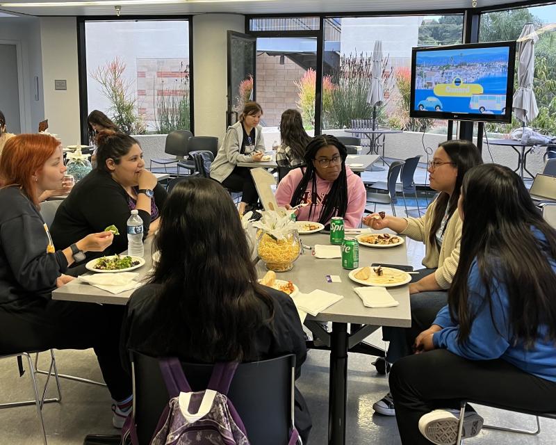 A group of students gathered around a table at a commuter dinner event.